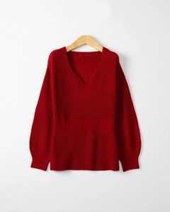 Détails de la maille et de la taille côtelée d'un pull bordeaux à col en V