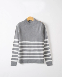 Detail of grey and white striped knit sweater with gold shoulder buttons on wooden hanger