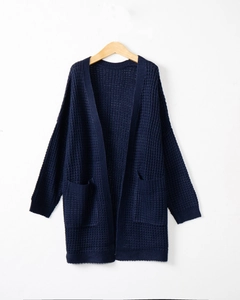 Detailed macro view of dark blue long cardigan showing the waffle knit texture and side pocket