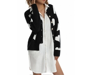 Close-up of black knit cardigan with white hearts and single-breasted button detail