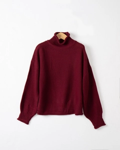 Dettaglio ravvicinato della trama a maglia grossa e del collo alto di questo maglione bordeaux