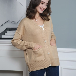 Detail of V-neck khaki knit cardigan with white buttons and large functional front pockets
