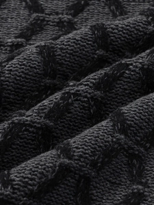 Close-up of premium dark grey knit sweater with detailed diamond jacquard texture