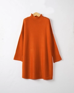 Detailed view of mock neck and soft knit texture on orange turtleneck sweater dress
