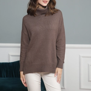 Detail showing loose fit drop shoulder and ribbed cuffs on brown knit sweater