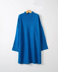 Detailed close-up of blue turtleneck knit dress with drop shoulder and ribbed texture