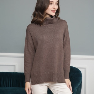 Detail of loose-fit brown knit sweater with ribbed hem and side slit craftsmanship