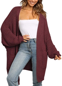 Close-up of burgundy chunky knit cardigan featuring oversized pockets and textured fabric