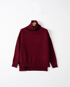 Detailed view of the side-slit hem and dense knit texture on the burgundy oversized sweater