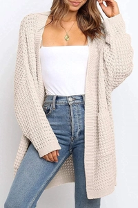 Detailed view of the chunky knit texture and square pocket on this cream cardigan