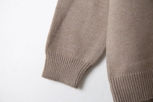Dettaglio dei polsini a coste e dell'orlo di questo cardigan in maglia taupe