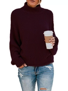Dettaglio della maglia grossa e del collo alto sul maglione oversize viola scuro