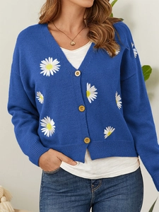 Detailed close-up of navy knit cardigan featuring delicate white daisy embroidery and V-neck