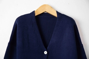 Detailed macro view of the dark blue V-neck knit cardigan with white buttons