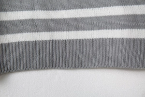 Close-up of grey and white striped knit fabric with detailed ribbed cuff texture