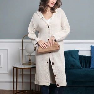Détail de gilet long en grosse maille crème avec capuche et boutons marron contrastants