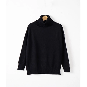 Close-up of black turtleneck knit sweater featuring ribbed collar and loose fit texture