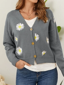 Close-up of grey V-neck knit cardigan featuring white daisy embroidery and wooden buttons