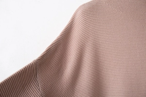Close-up of pink high-density knit sweater fabric showing fine stitching and texture