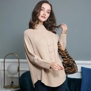 Detail of the cable knit pattern and ribbed cuffs on the beige turtleneck sweater