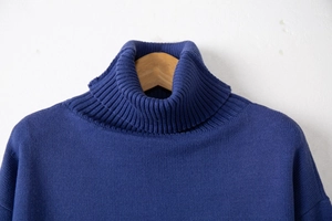Detail of the thick ribbed turtleneck and fine knit texture of this navy blue wool sweater
