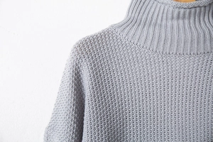 Dettaglio del maglione a collo alto grigio chiaro con trama a maglia a coste spesse