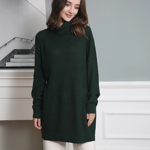 Close-up of dark green ribbed knit texture on a high neck longline loose sweater