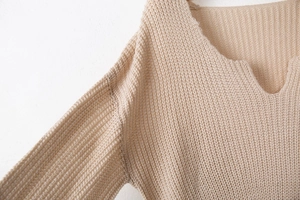 Détail du tissu en maille abricot clair avec texture côtelée et design à col en V chic