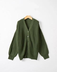Dettaglio della trama in maglia a nido d'ape verde scuro e bottoni rotondi sul cardigan