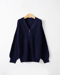Dettaglio trama a nido d'ape e chiusura con bottoni sul cardigan in maglia blu navy