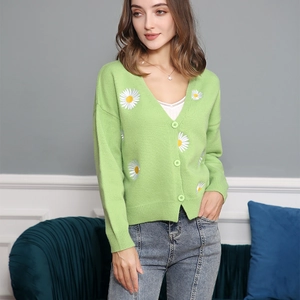 Close-up of grass green knit cardigan featuring delicate daisy embroidery and buttons
