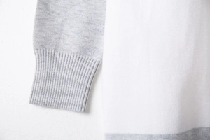 Macro shot of ribbed cuffs and high-quality knit texture on a color-block sweater cardigan