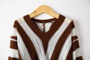 Detailed close-up of hollow knit texture and brown striped pattern on the V-neck sweater