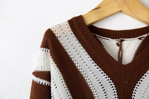 Detailed view of striped knit sweater with V-neckline and hollow-out crochet pattern details