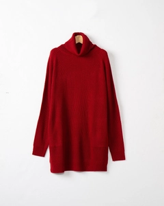 Detail of red turtleneck knit sweater showing ribbed texture and long sleeve cuffs
