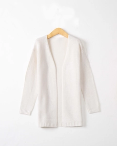 Detail of white knit cardigan showing vertical ribbed texture and soft wool fabric