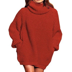 Detail of red oversized turtleneck knit dress showing thick ribbed texture and long sleeves