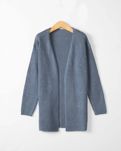 Detail of blue chunky knit cardigan texture with ribbed cuffs on a wooden hanger