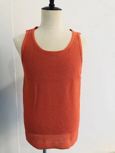 Detail eines orangefarbenen Strick-Tanktops mit strukturierter Strickware und Rundhals