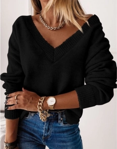 Close-up of ribbed V-neckline and sleeve cuffs on this black loose knit sweater