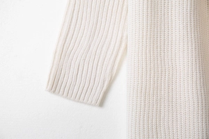 Detailed macro view of cream knitted cardigan showing thick texture and ribbed cuffs