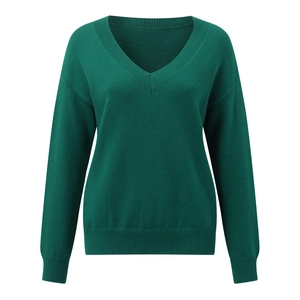 Detail of dark green V-neck sweater showing fine knit fabric and ribbed cuffs finish