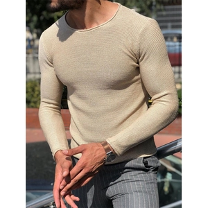 Dettaglio di un maglione in maglia crema slim fit che mostra la morbida trama del tessuto