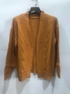 Close-up of mustard yellow chunky knit cardigan showing thick cable stitch texture