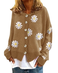 Close-up of marble texture buttons and daisy embroidery on camel knit cardigan