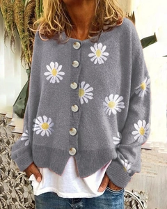 Detailed close-up of grey knit cardigan featuring embroidered daisy patterns and resin buttons