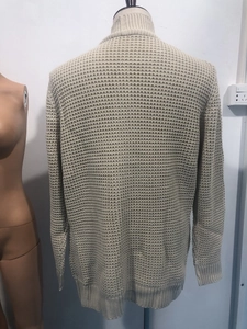 Gros plan détaillé du gilet en maille gaufrée beige avec poignets et ourlet côtelés