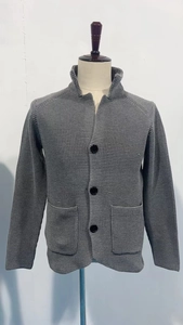 Close-up of dark grey men's waffle knit cardigan featuring stand collar and buttons