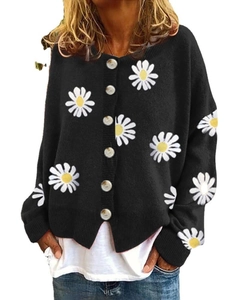 Close-up of black knit cardigan with white daisy embroidery and textured dark buttons