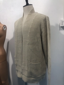 Détail d'un cardigan beige pour homme en maille gaufrée avec des poches latérales